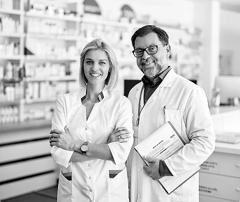 Farmaceuci w aptece pozujący do zdjęcia